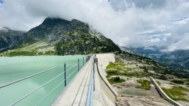 Die Staumauer am Gelmersee mit türkisem Wasser.