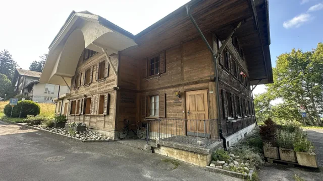 Una vecchia casa di legno a bordo strada.