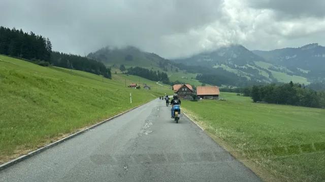 Motociclisti su una strada tra i prati.