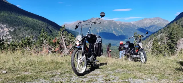 Due motorini davanti a una catena di montagne.