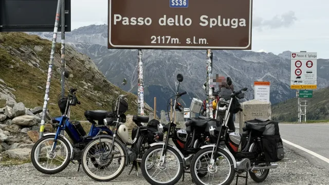 Motorini al cartello del passo dello Spluga.