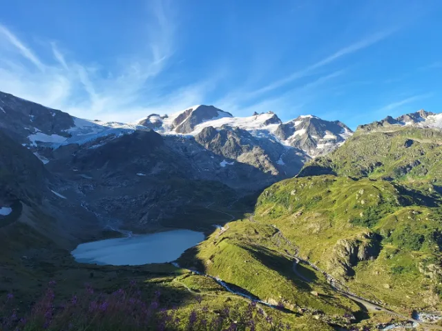 Gletschersee unter verschneiten Gipfeln.