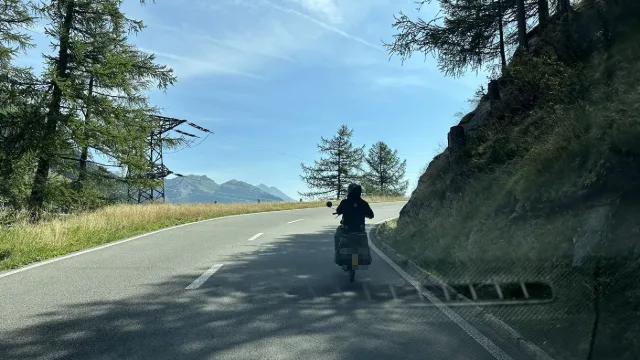 Un motociclista su una strada di montagna.