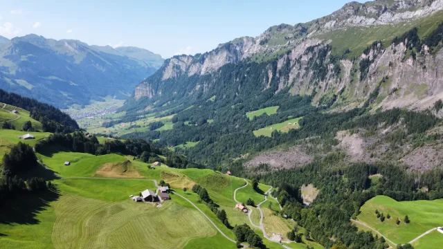 Una valle verde sotto le pareti rocciose, vista dall'alto.