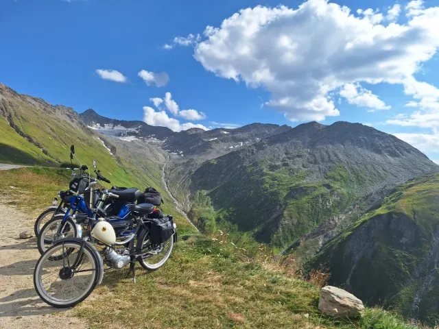 Un motorino davanti a montagne e nuvole.