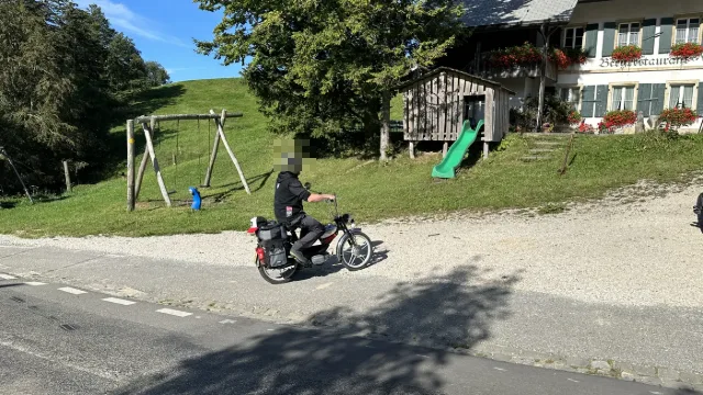 Ein Töffli vor einem Bauernhaus.