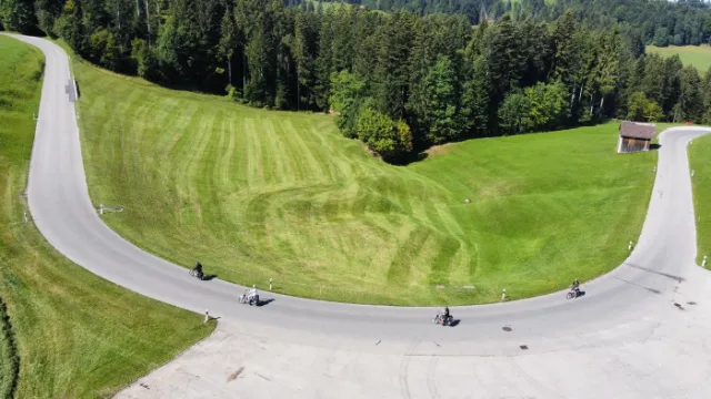 Eine Kurve im Appenzellerland mit Töfflifahrern, von oben.