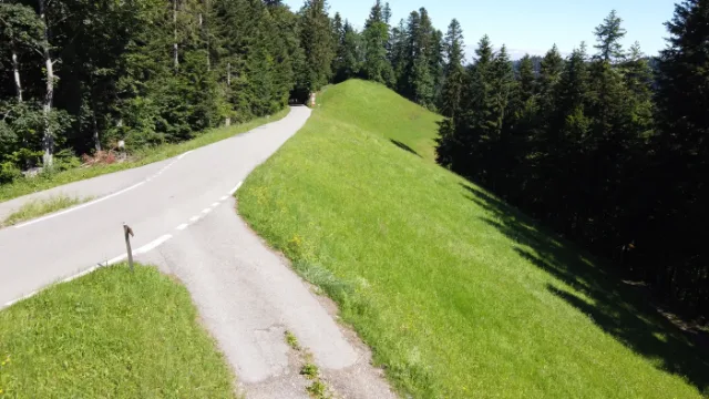 Eine schmale Strasse über einen grünen Grat.